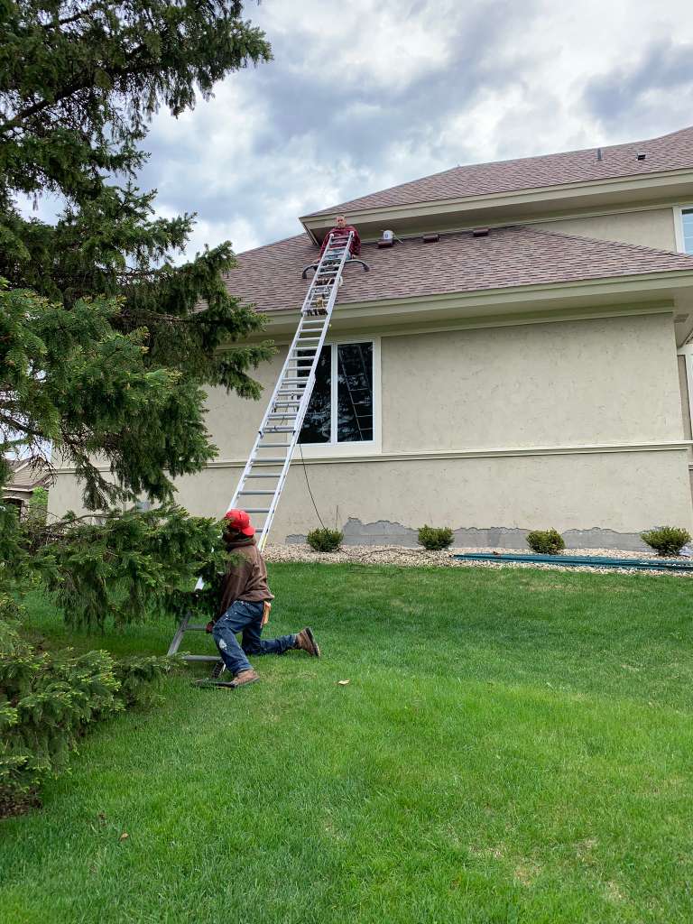 Team painting large stucco home exterior